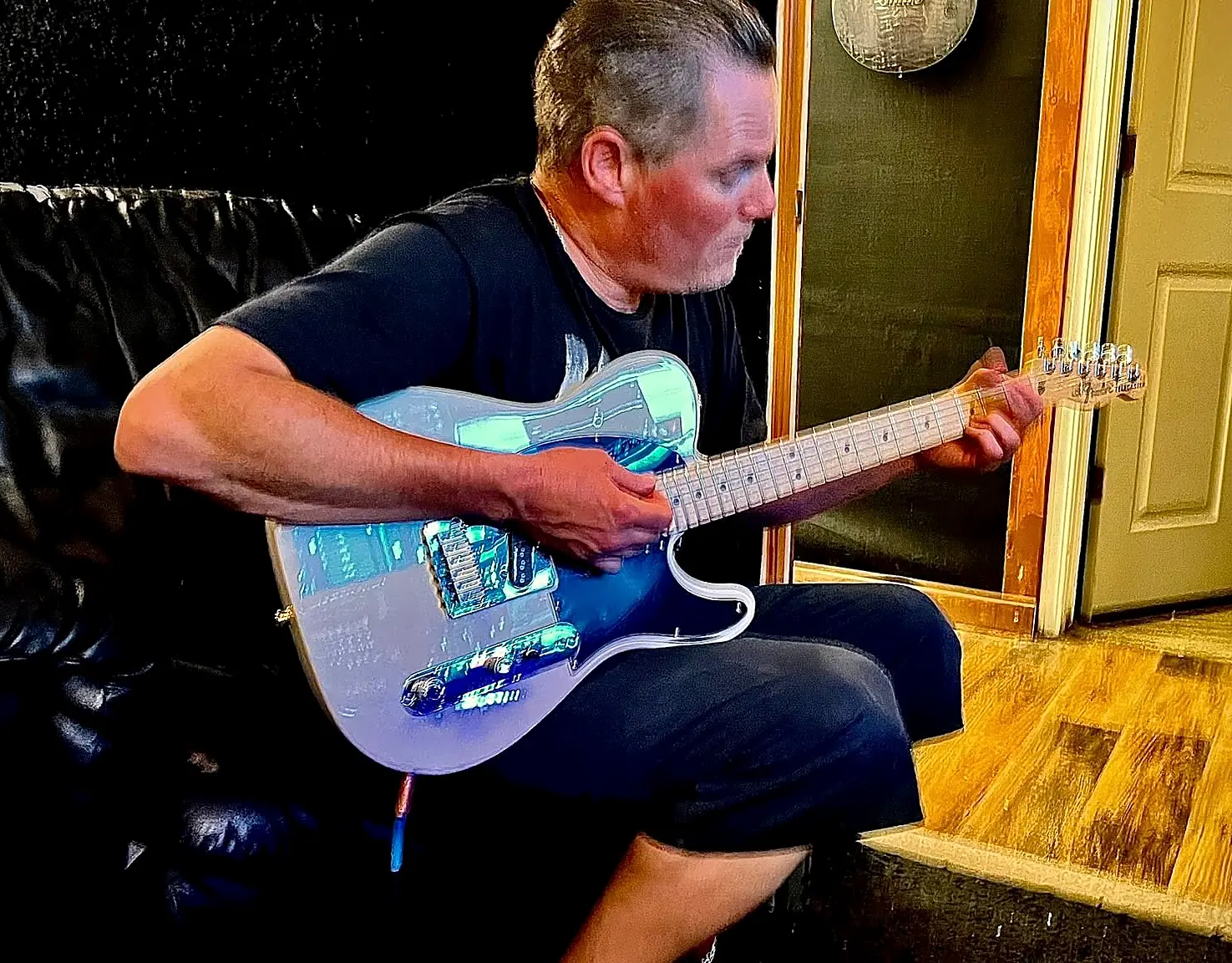 Richard Easterling playing a blue electric guitar in the studio with Lamb Bed